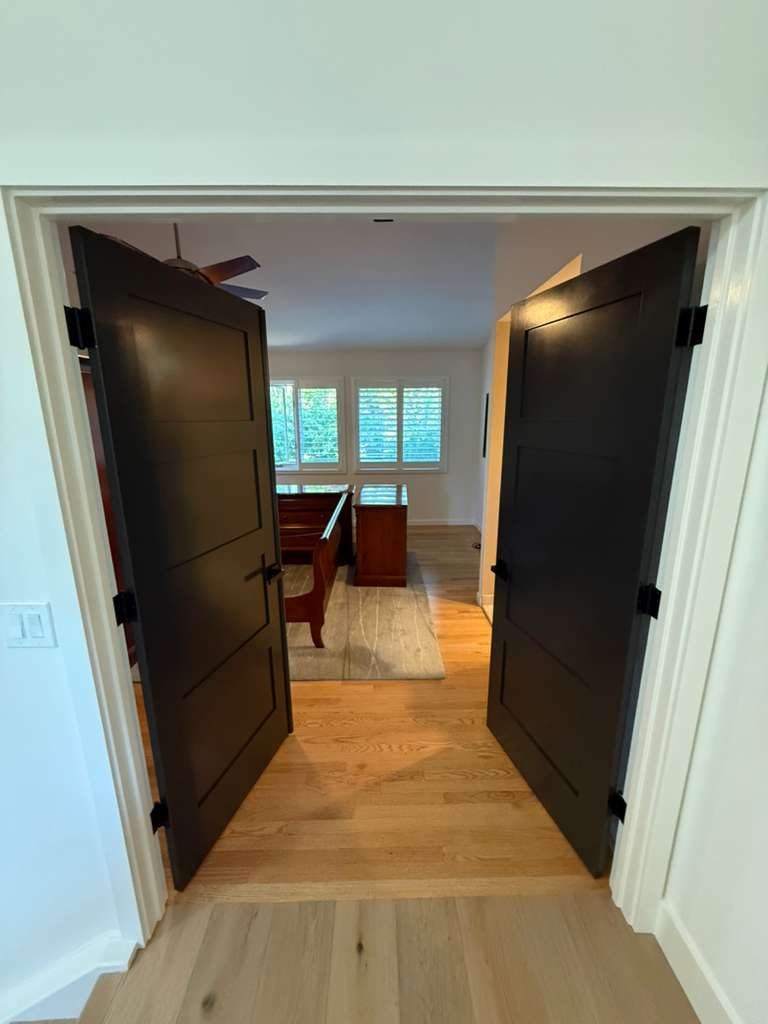 Sleek black double doors on white oak floors, precision door finishing