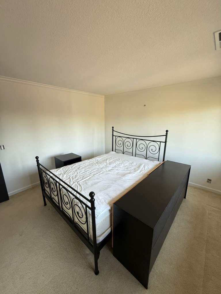 Freshly painted master bedroom with crisp walls, crown molding and clean textured ceiling. Luxury interior repaint by Alliance Trio Solutions